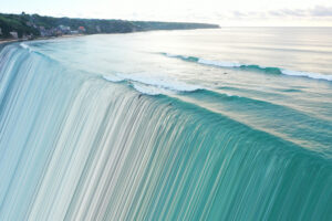 Image of sea from above distorted and transforming into stripe pattern.