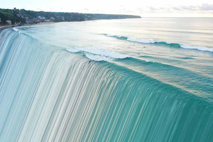 Image of sea from above distorted and transforming into stripe pattern.